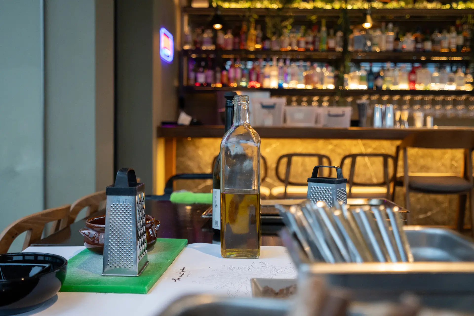 The Artist Athens kitchen setup — olive oil bottle and graters on the preparation table