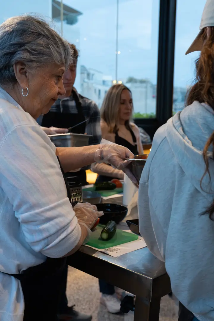 Participant focused on cutting cucumber — authentic hands-on cooking moment